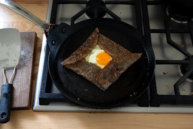 A skilled holding an egg-and-gruyere filled buckwheat crepe.