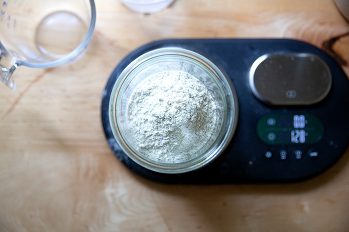 A Weck jar on a scale holding sourdough starter, flour, and water.