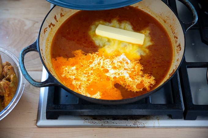 A braiser filled with the sauce for butter chicken plus a stick of butter and 1/4 cup heavy cream.