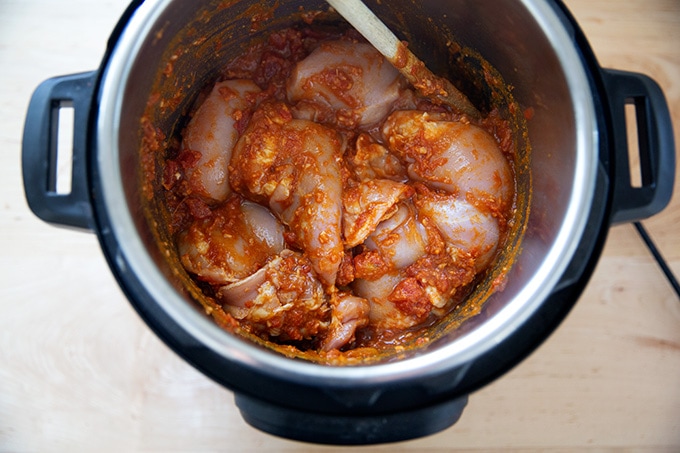 An Instant Pot filled with the ingredients to make butter chicken.