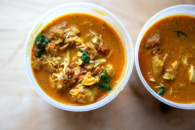 Quart containers filled with butter chicken.