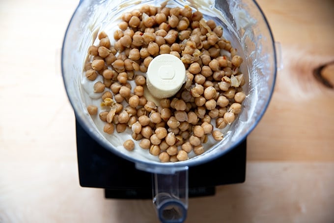 A food processor holding the makings of homemade hummus.