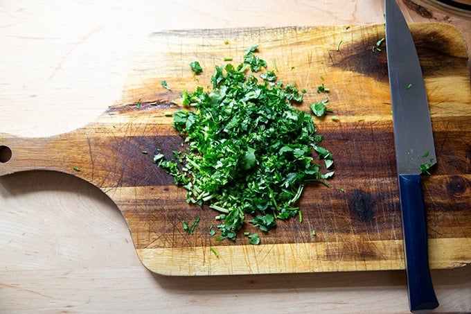 Chopped cilantro on a cutting board. - 16