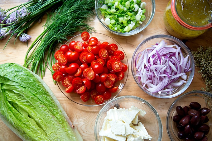 Ingredients to make Greek salad on a countertop.