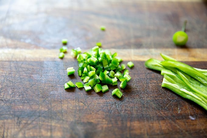 Chopped hot green chili on a board.