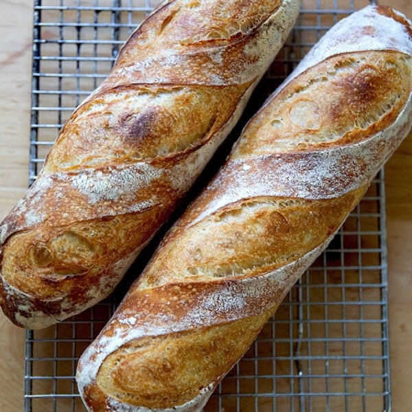 Two baguettes on a cooling rack.