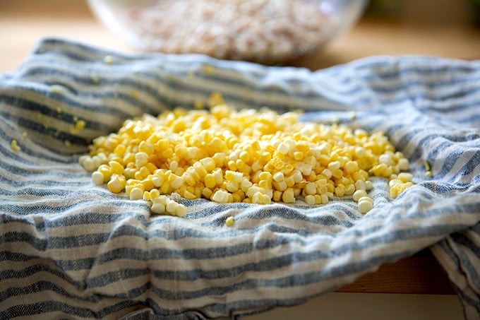 Corn removed from the cob in a tea towel on a countertop.