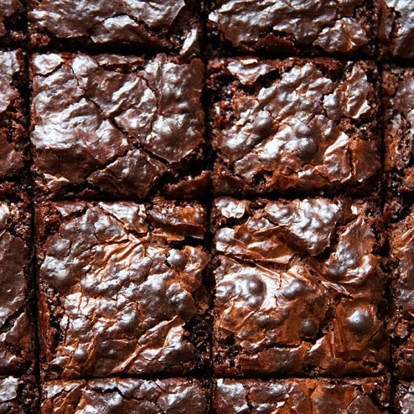 An up close photo of cut brownies on a board.