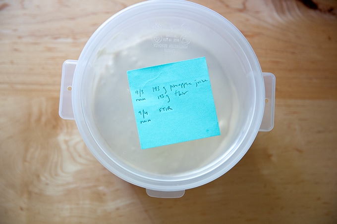 A covered 2-quart container with a post-it note on top.