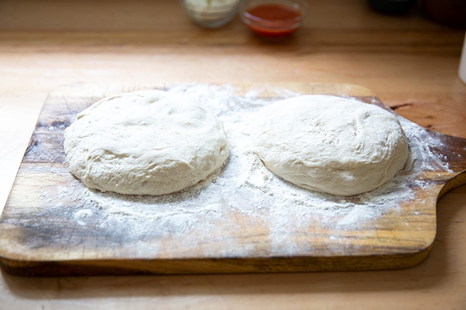 Two rounds of dough on a floured board.