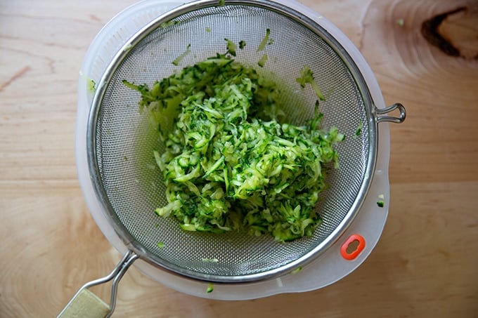 Grated zucchini in a colander.