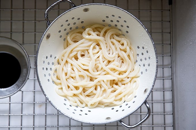 Drained udon noodles in the sink.