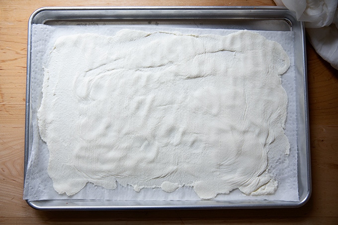 Drained ricotta on a paper-towel-lined sheet pan.