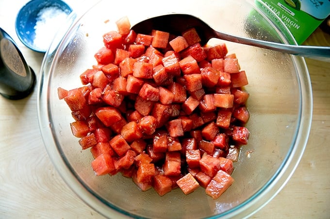 Cubed watermelon dressed with balsamic and olive oil in a large bowl.