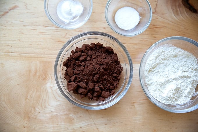 The dry ingredients to make brownies measured out in bowls.