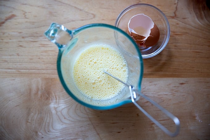 A two-cup measure filled with an egg whisked together with some milk.