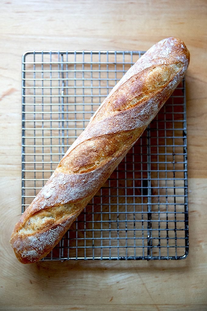 One baguette on a cooling rack.