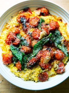 A bowl of fresh corn polenta with blistered cherry tomatoes.