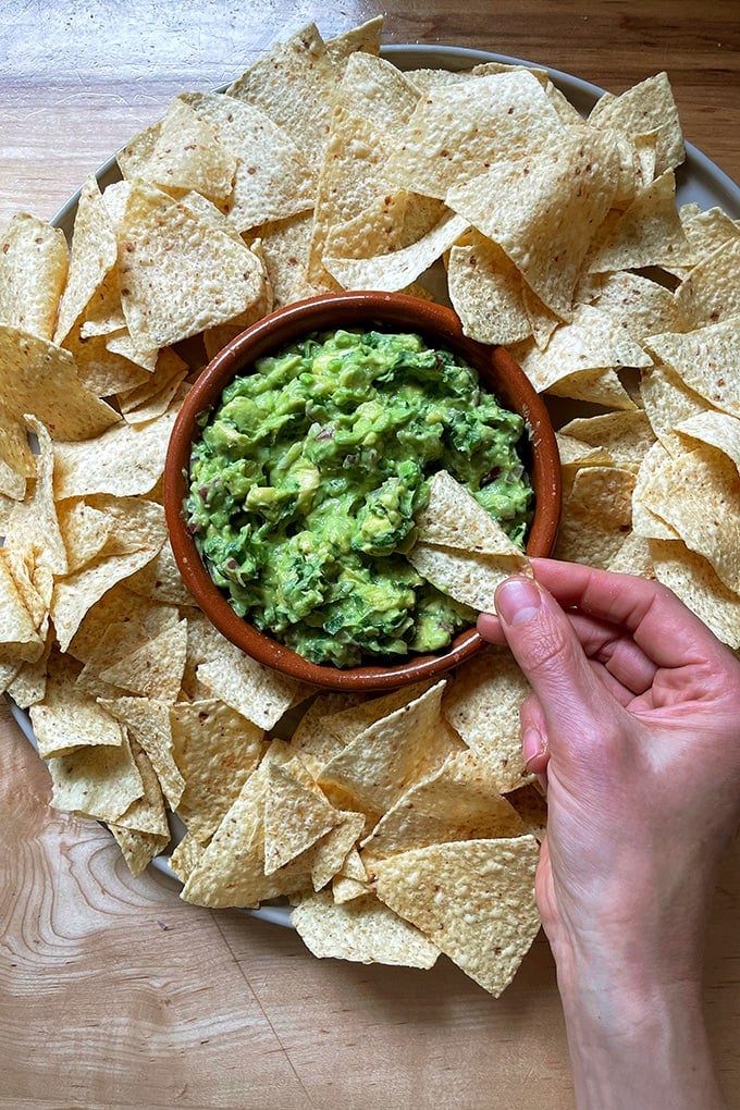 A platter of chips and guacamole.