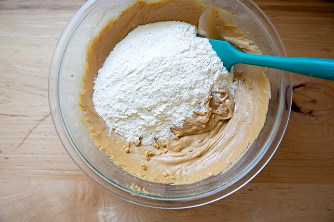 A large bowl holding peanut butter cookie batter with the flour just added.