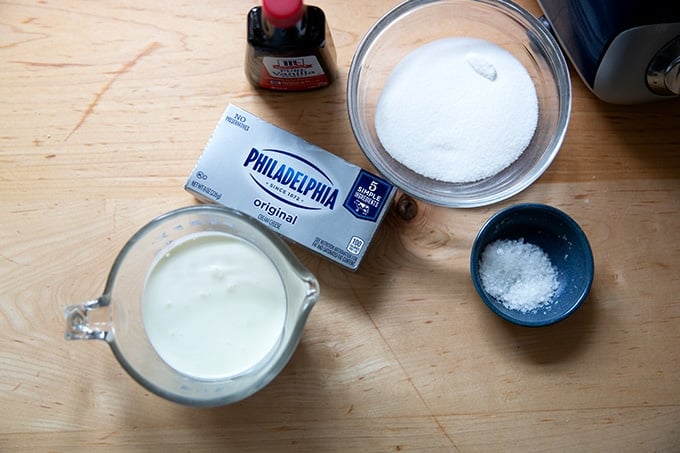 Ingredients to make whipped cream - cream cheese frosting on a countertop.