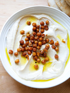 A platter of homemade hummus topped with crispy chickpeas.