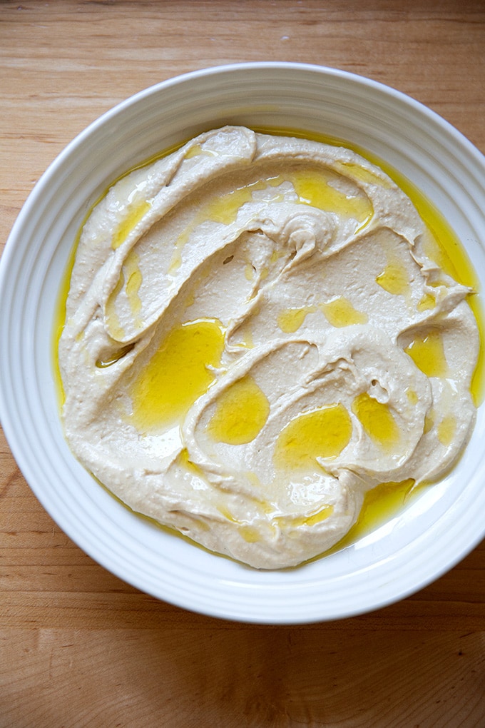 A platter of homemade hummus, drizzled with olive oil.