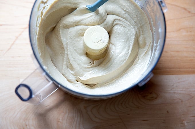 A food processor holding just-made homemade hummus.