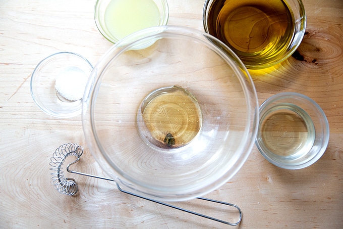 The ingredients to make lemon vinaigrette on a countertop.