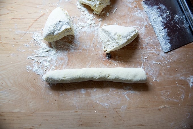 A log of ricotta gnocchi dough rolled out on a floured work surface.