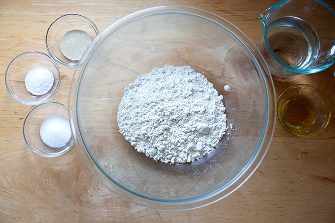 The ingredients to make gluten-free pizza dough, measured out, on a countertop.