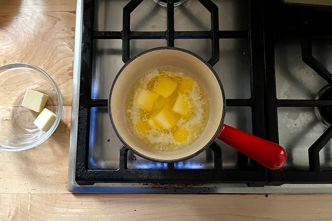 Butter melting on the stovetop in a skillet.