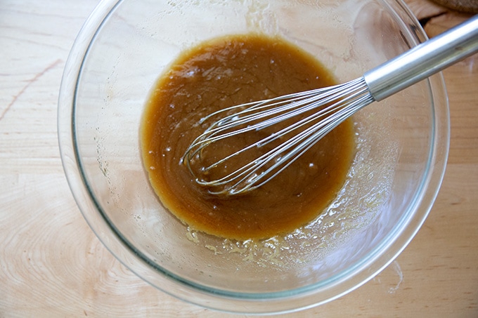 A bowl of melted butter, vanilla, and brown sugar all mixed together.