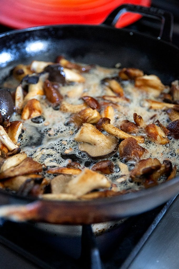 A skillet holding brown butter mushrooms.
