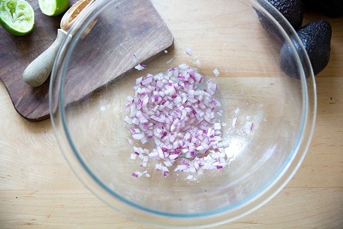A bowl holding red onion macerating in fresh lime juice.