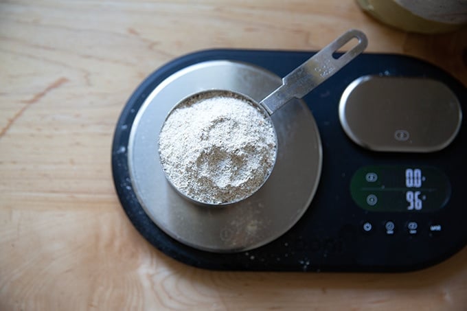 A cup of rye flour on a scale.