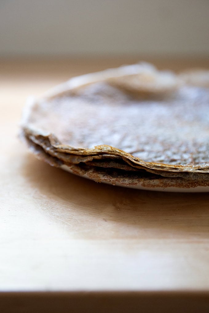 A stack of cooked buckwheat crepes on a plate.