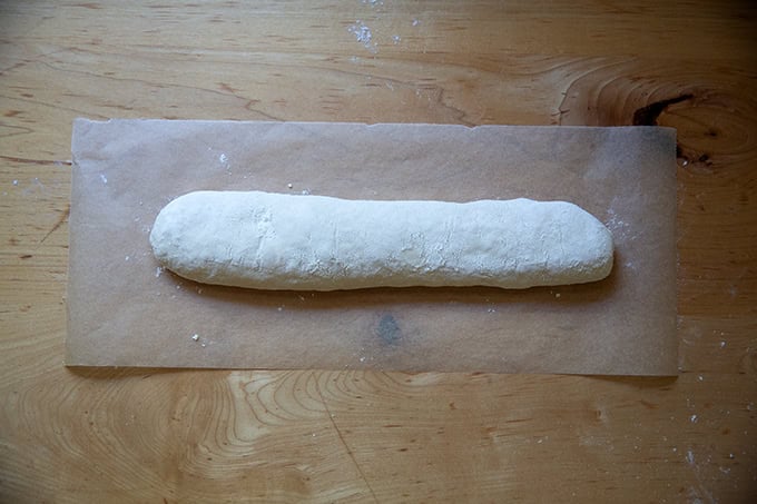 An unbaked baguette ready to be scored.