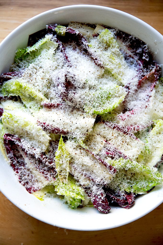 A bowl of Caesar salad covered with finely grated parmesan.