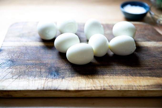 Eight hard-cooked eggs on a board.