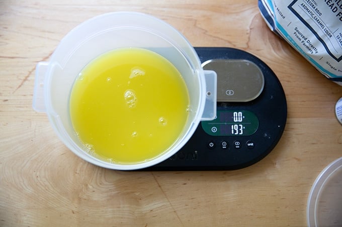 A 2-quart container on a scale holding pineapple juice.