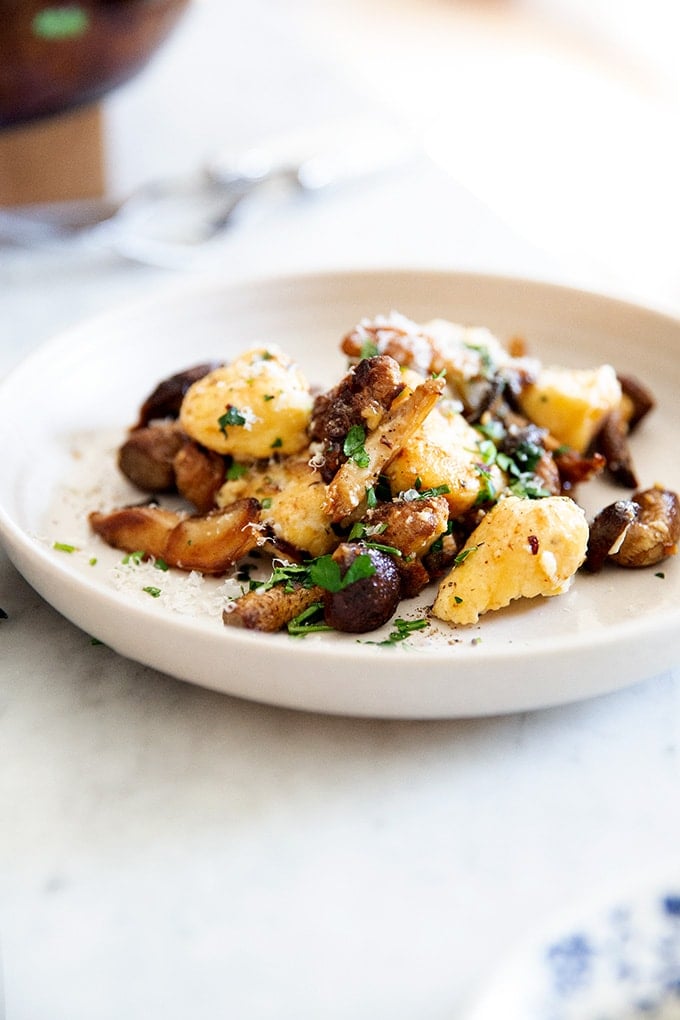 A plate of ricotta gnocchi tossed in brown butter mushrooms.