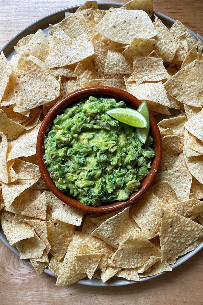 A platter of homemade guacamole and chips.
