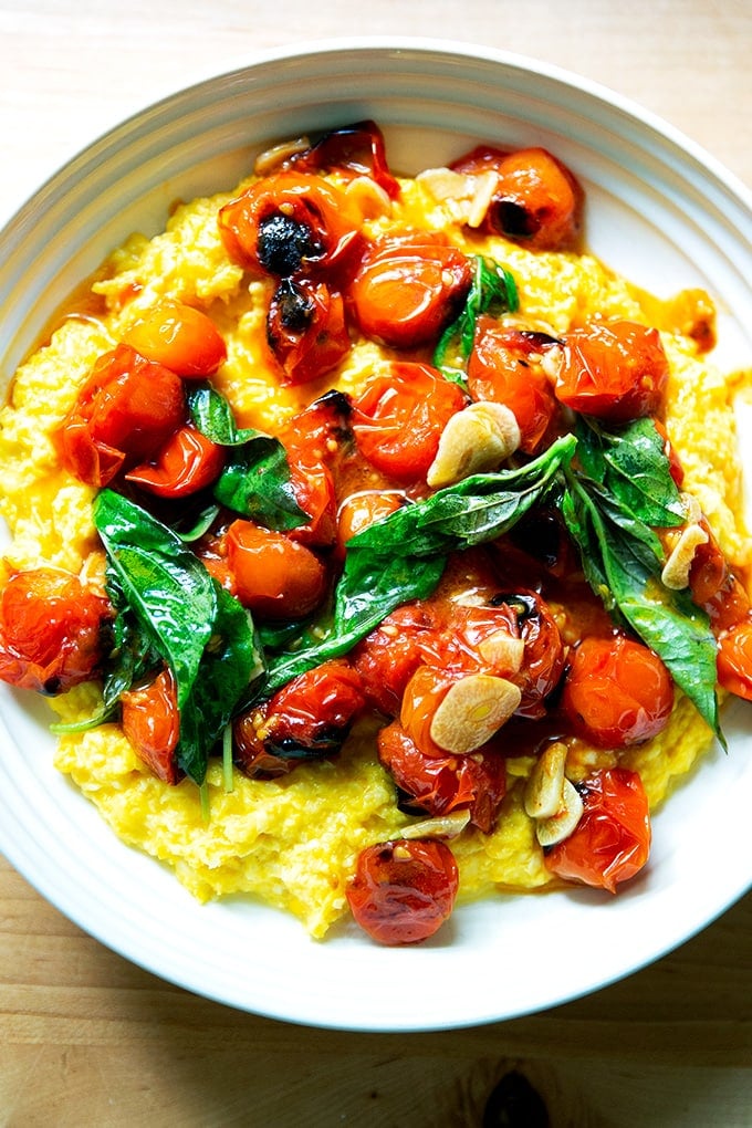 A bowl of fresh corn polenta with blistered cherry tomatoes.