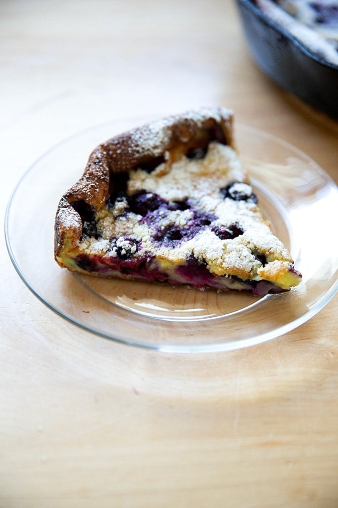 A slice of a blueberry Dutch baby on a plate.