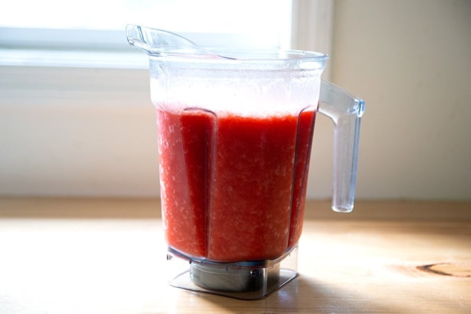 A blender filled with pureed strawberry paloma slushies.