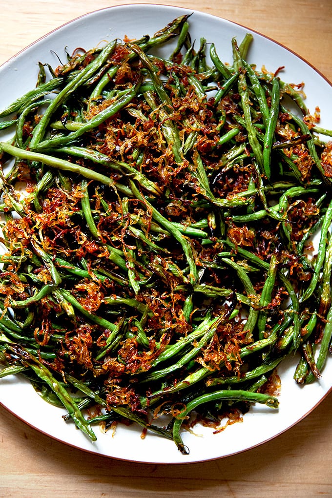 A platter of roasted green beans with crispy fried shallots.