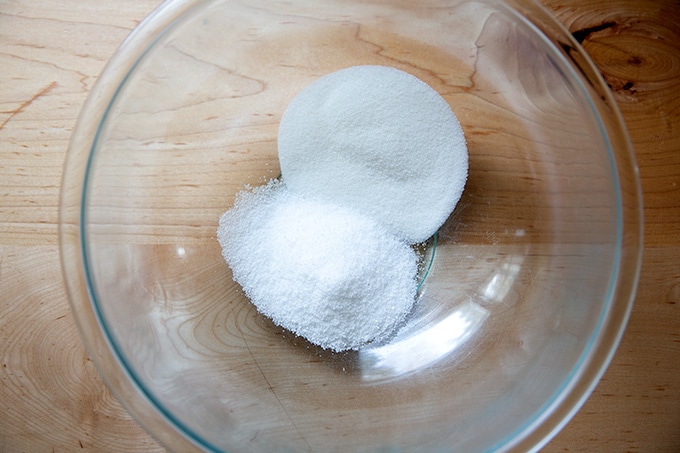 A large glass bowl filled with 1/4 cup each salt and sugar.