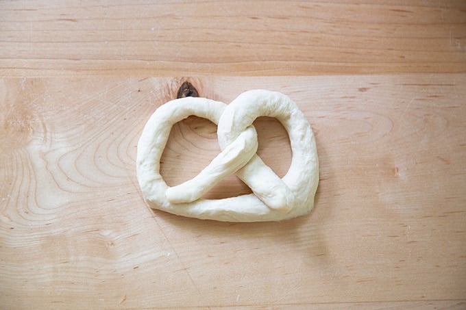 An unbaked soft pretzel on a counter top.