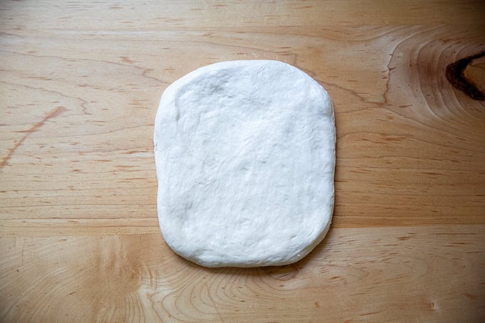 A flattened round of baguette dough.